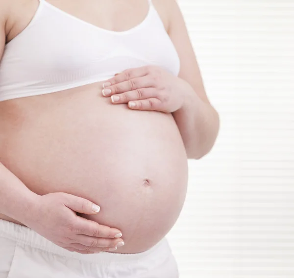 Pregant žena drží jeho břicho — Stock fotografie