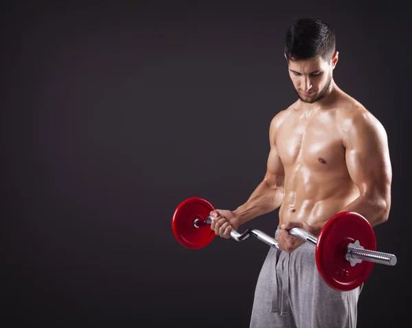 Fitness-Mann stemmt Gewichte mit Curlstange — Stockfoto