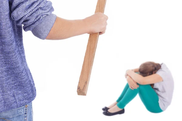 Niño sosteniendo un palo de madera para golpear a una niña — Foto de Stock