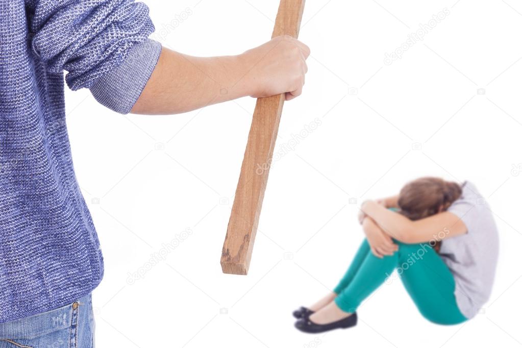 Boy holding a wooden stick to beaten on a little girl
