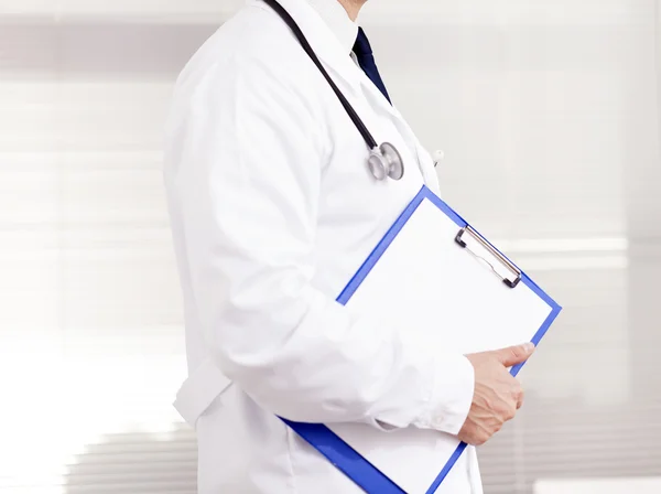 Doctor holding a clipboard at the clinic — Stock Photo, Image