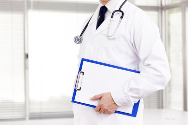 Klinikte bir mavi Pano tutan doktor