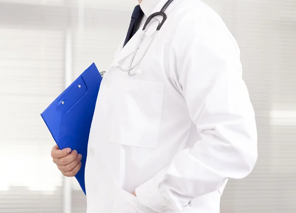 Dottore in possesso di un blocco a molla blu nel suo ufficio — Foto Stock