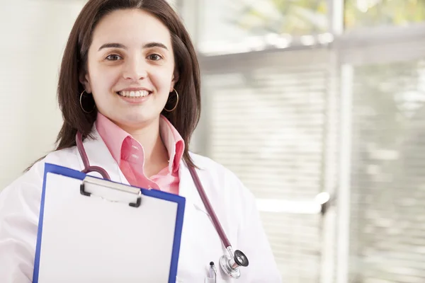 Женщина-врач держит медицинский планшет — стоковое фото