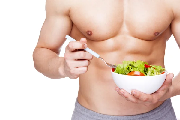 Fitness man håller en skål med sallad — Stockfoto