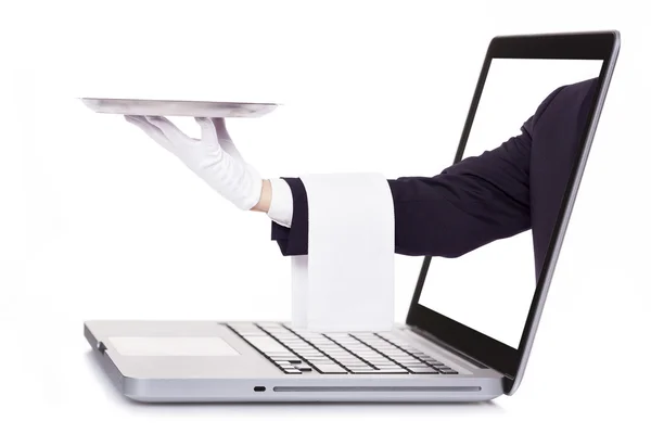 Waiter hand holding a silver tray through a laptop — Stock Photo, Image