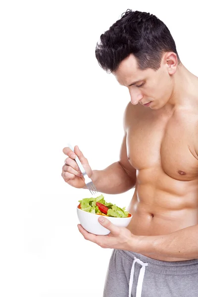 Fitness man håller en skål med sallad — Stockfoto