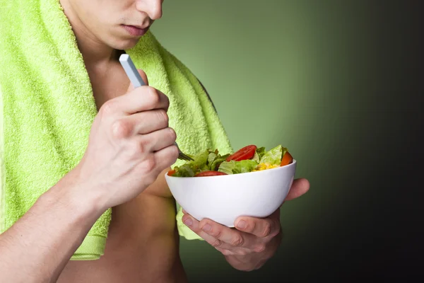 Fitness man med en skål med färsk sallad — Stockfoto