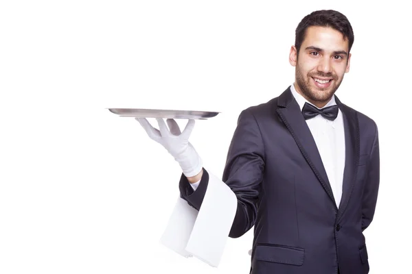 Camarero sonriente sosteniendo una bandeja de plata vacía — Foto de Stock