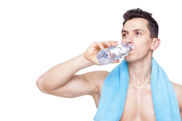 Muscular fit man drinking a bottle of water — Stock Photo, Image