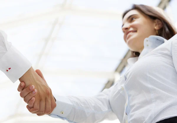 Beautiful businesswoman giving a handshake and smiling — Stock Photo, Image