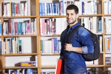Kütüphanede gülümseyen erkek öğrenci
