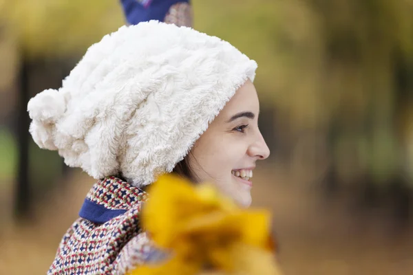 Femme tenant des feuilles d'automne au parc — Photo