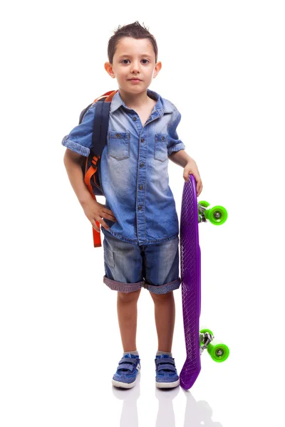 Schooljongen permanent met een skateboard — Stockfoto