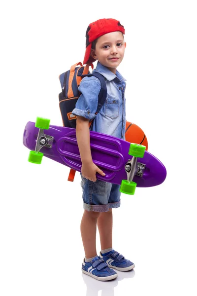 Schooljong geitje holding een skateboard en een basketbal — Stockfoto