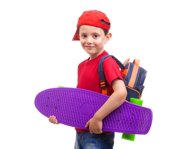Smiling schoolkid standing with skateboard — Stock Photo, Image