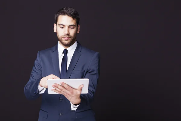 Empresário de pé com um computador tablet — Fotografia de Stock