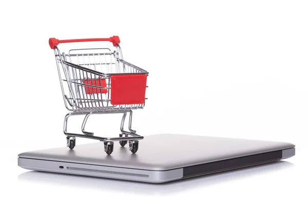 Shopping cart over a laptop computer — Stock Photo, Image
