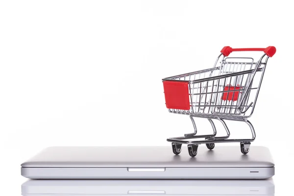 Shopping cart over a laptop computer — Stock Photo, Image