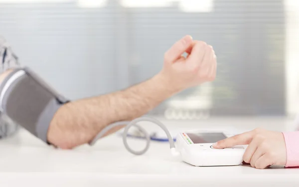 Doctor checking patient blood pressure — Stock Photo, Image