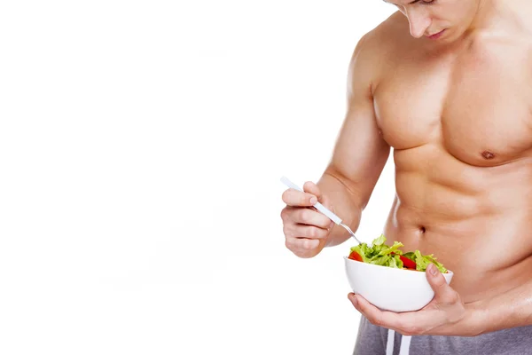 Strong fitness man holding a bowl of salad — Stock Photo, Image