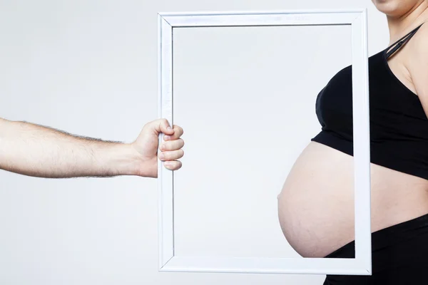 Man hand framing the belly of a pregnant woman — Stock Photo, Image