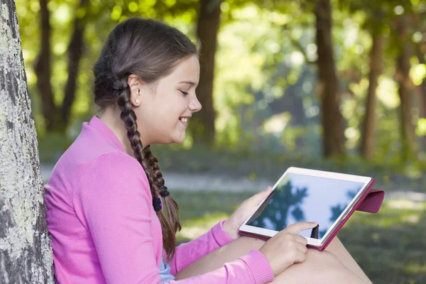Flickan med en tablett dator utomhus — Stockfoto