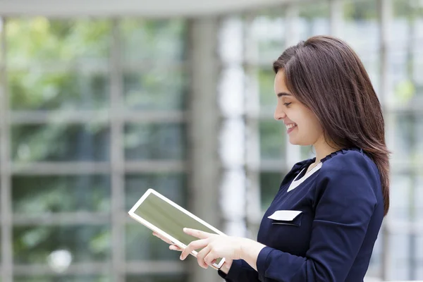 Femme d'affaires souriante tenant un ordinateur tablette — Photo