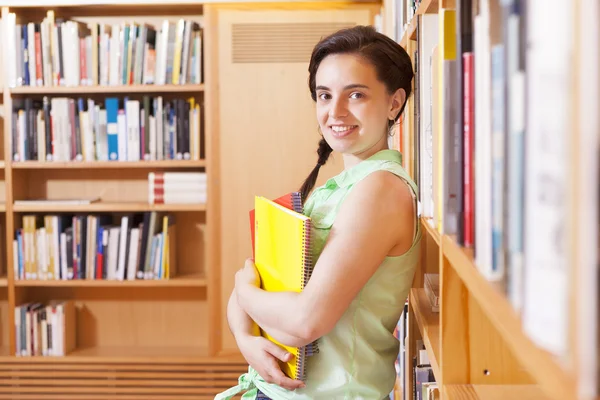 Kız öğrenci üniversite kitaplık üzerine eğilerek — Stok fotoğraf