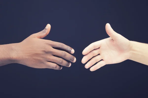 Africano e um homem caucasiano apertando as mãos — Fotografia de Stock