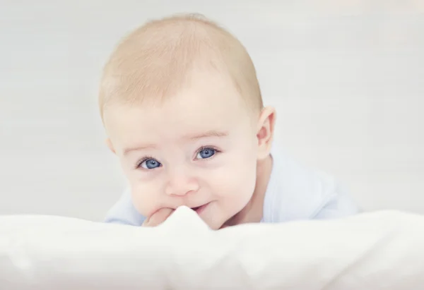 Adorável bebê sorridente deitado na cama — Fotografia de Stock