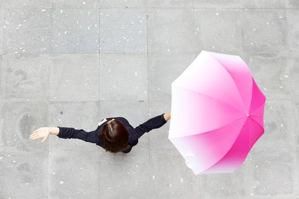 Kobieta z otwartymi ramionami trzymając parasol — Zdjęcie stockowe