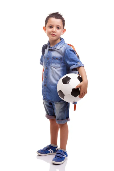 Bir futbol topu ve sırt çantası ile ayakta okullu çocuk — Stok fotoğraf