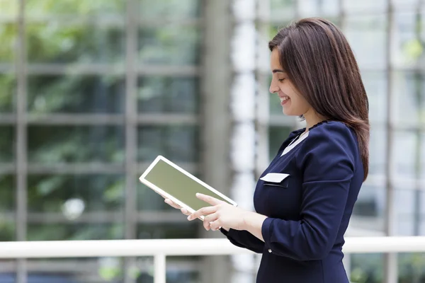 Mujer de negocios sonriente sosteniendo una tableta — Foto de Stock