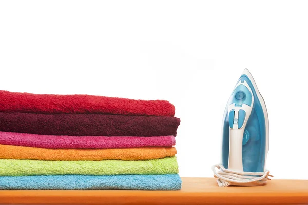 Asse da stiro con asciugamani colorati — Foto Stock