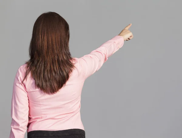 Young woman pointing to copy space — Stock Photo, Image