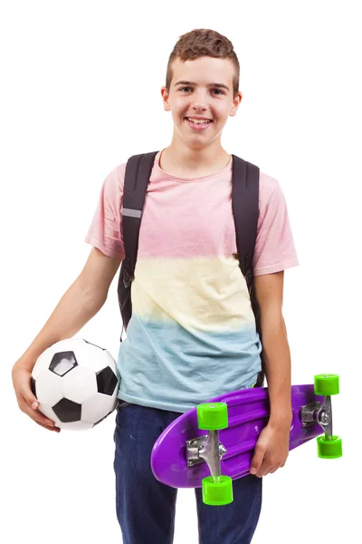 Menino da escola segurando um skate e uma bola de futebol — Fotografia de Stock
