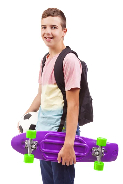 Menino da escola segurando um skate e uma bola de futebol — Fotografia de Stock