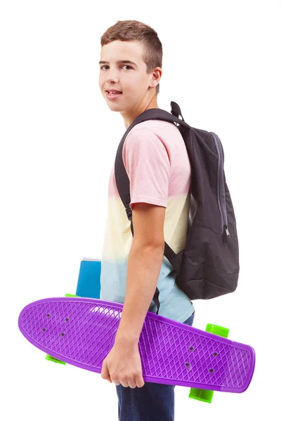 Skolan pojke håller en skateboard och bärbara datorer — Stockfoto