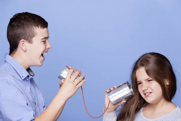 Crianças brincando com uma lata como um telefone — Fotografia de Stock