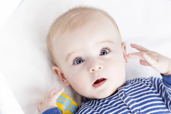 Bebê com olhos azuis brincando com um brinquedo — Fotografia de Stock