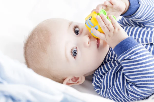 Baby with blue eyes playing with a toy — Stock Photo, Image