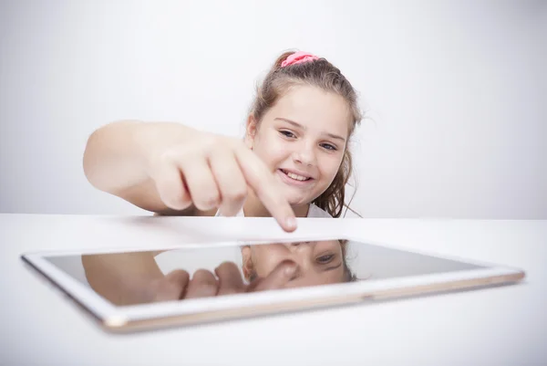 Sorrindo menina brincando com um computador tablet — Fotografia de Stock