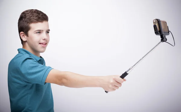 Adolescente chico usando un selfie stick — Foto de Stock