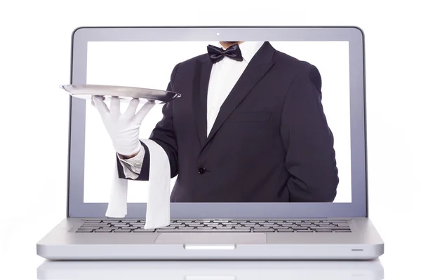 Servitören handen håller en silverbricka genom en laptop — Stockfoto