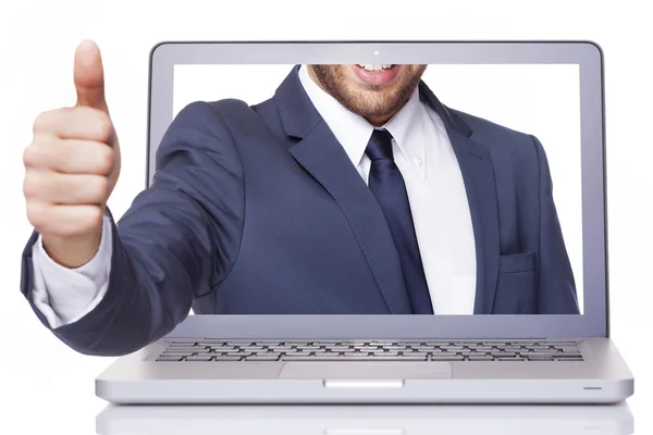 Деловой человек поднимает большой палец через ноутбук — стоковое фото