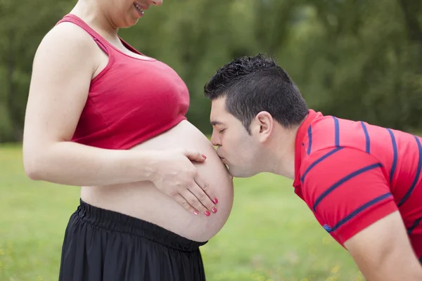 Mężczyzna całuje brzuch jego kobieta w ciąży — Zdjęcie stockowe