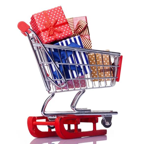 Red sled and shopping cart with gift boxes — Stock Photo, Image