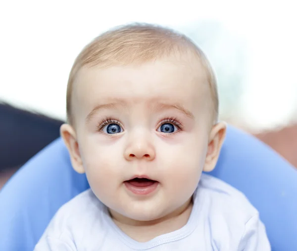 Bebê sentado em uma cadeira olhando para a câmera — Fotografia de Stock