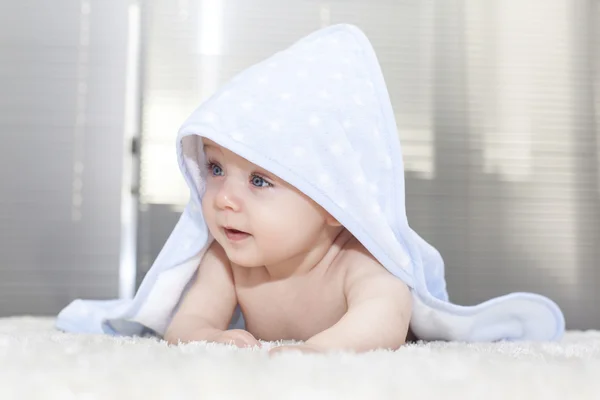 ベッドで横になっているタオルの上に青い目の赤ちゃん — ストック写真